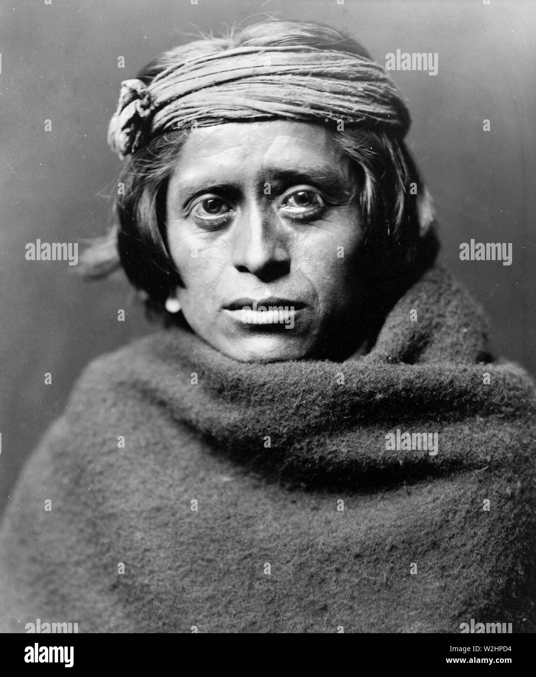 Edward S. Curtis nativi indiani americani - Ritratto di un Zuni uomo che indossa la fascia frastagliata e coperta Foto Stock