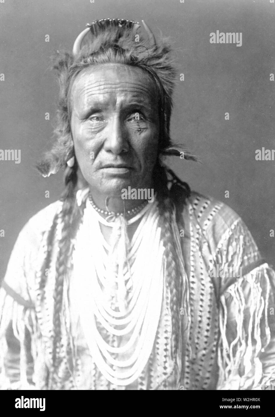 Edward S. Curtis nativi indiani americani - l'Orso grizzly, Piegan, mezza lunghezza ritratto ca. 1910 Foto Stock