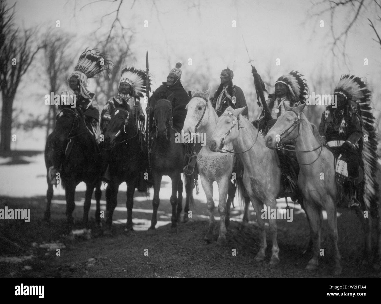 Sei capi tribali (l a r) Poco Plume (Piegan), Charley Daino (UTE), Geronimo (Apache Chiricahua), Quanah Parker (Comanche), Cavo avvisatore acustico Bear (Brulé Sioux), e Cavallo americano (Oglala Sioux) a cavallo in vesti cerimoniali Foto Stock