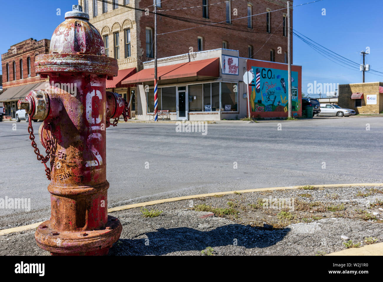 Vecchio rosso idrante, su vuoto angolo di strada, Hondo, Texas, Stati Uniti d'America Foto Stock