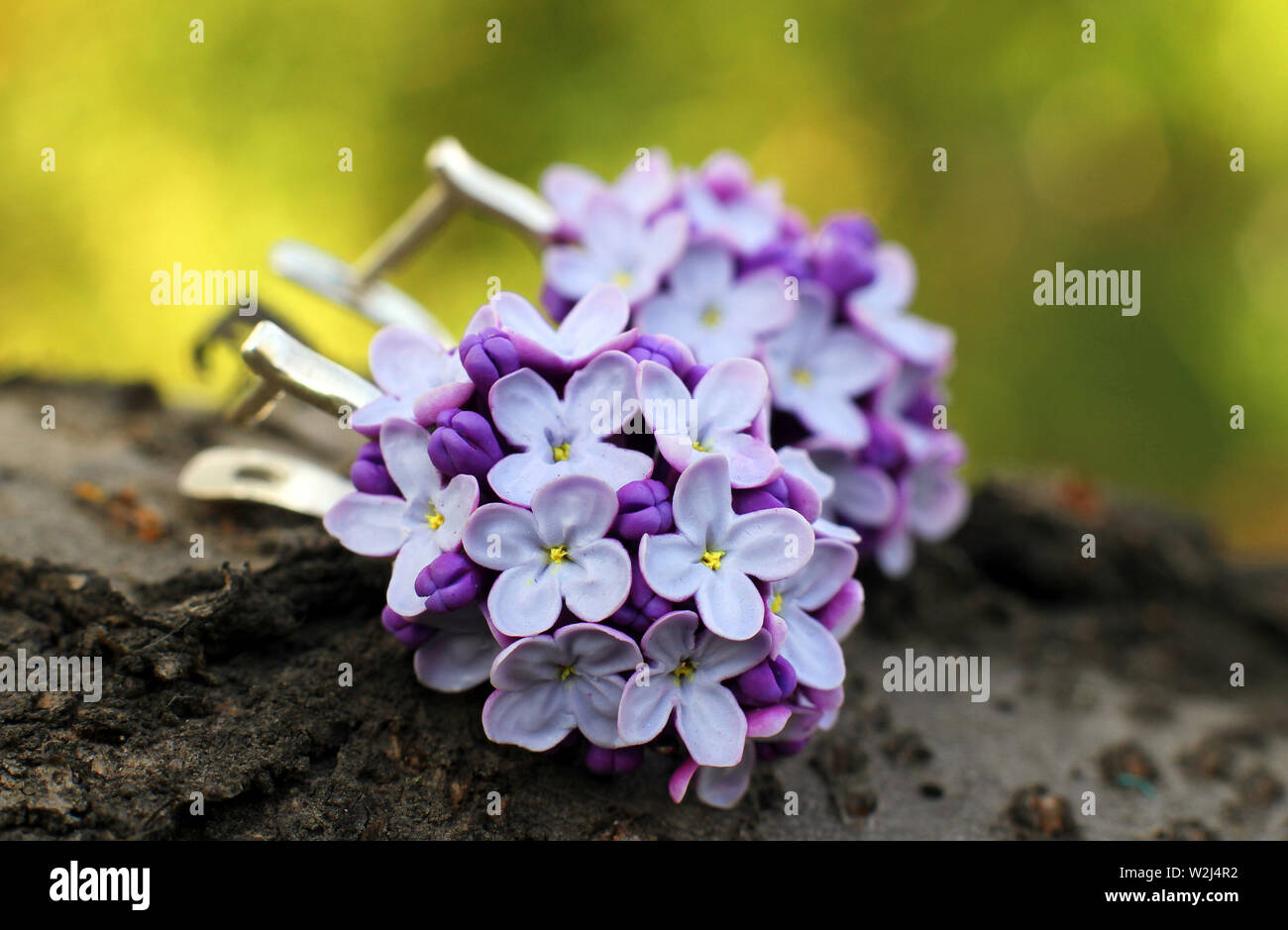 Fatto a mano gli orecchini a forma di fiori da polymer clay su sfondo di legno Foto Stock