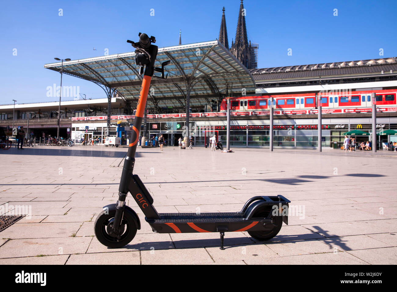 Circ scooter elettrici per biciclette presso la stazione ferroviaria principale, la cattedrale di Colonia, Germania. Circ Elektroscooter zum mieten am Hauptbahnhof, Der Dom, koel Foto Stock