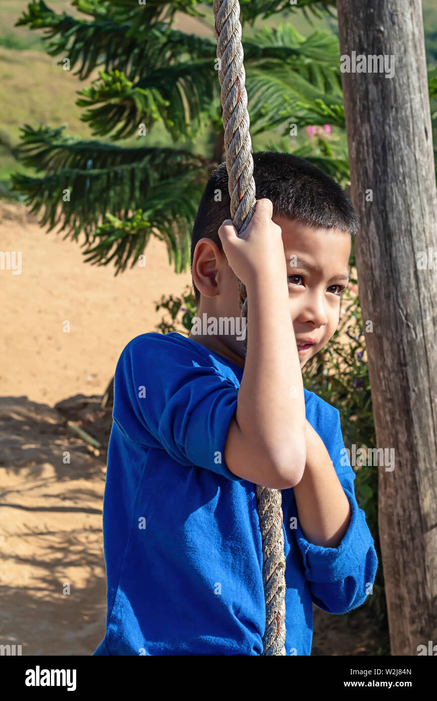 L'Asean boy in corrispondenza dei nodi la corda e sorridente felicemente. Foto Stock