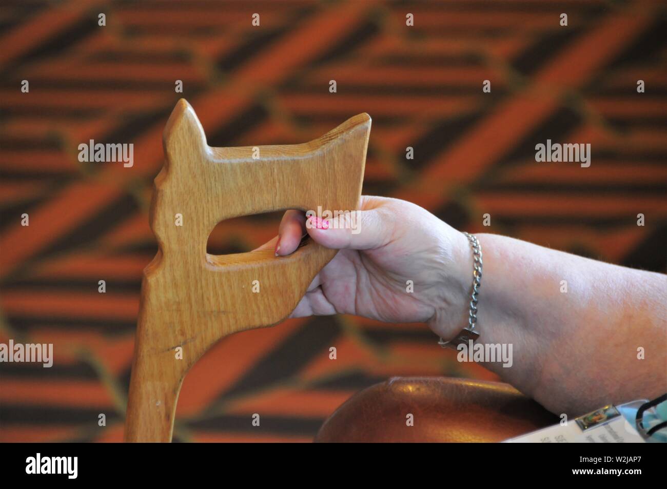 Donna con la sua canna da zucchero fatta dal marito per aiutare con i piedi a causa di invalidità del ginocchio e la sua caduta Foto Stock