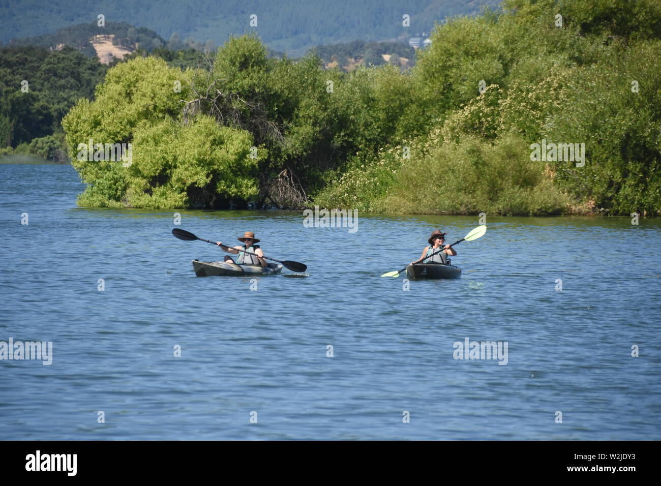 Le donne in kayak sul lago chiara California USA America sulla calda estate mattina per svago e divertimento - reale più grande di acqua fresca naturale lago in CA Foto Stock