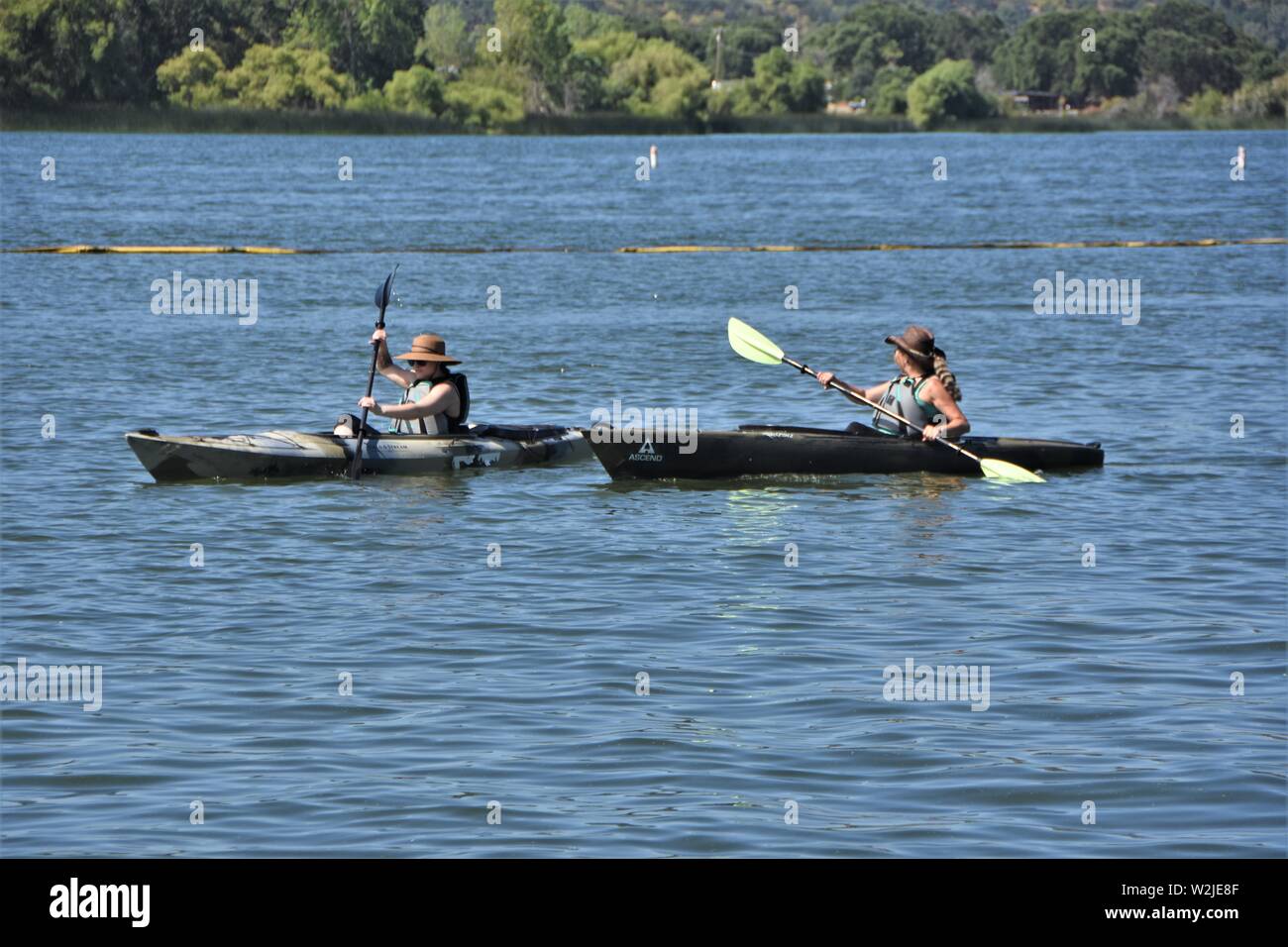 Le donne in kayak sul lago chiara California USA America sulla calda estate mattina per svago e divertimento - reale più grande di acqua fresca naturale lago in CA Foto Stock