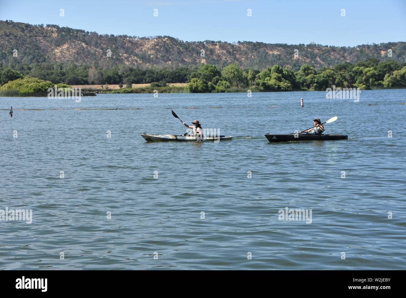 Le donne in kayak sul lago chiara California USA America sulla calda estate mattina per svago e divertimento - reale più grande di acqua fresca naturale lago in CA Foto Stock