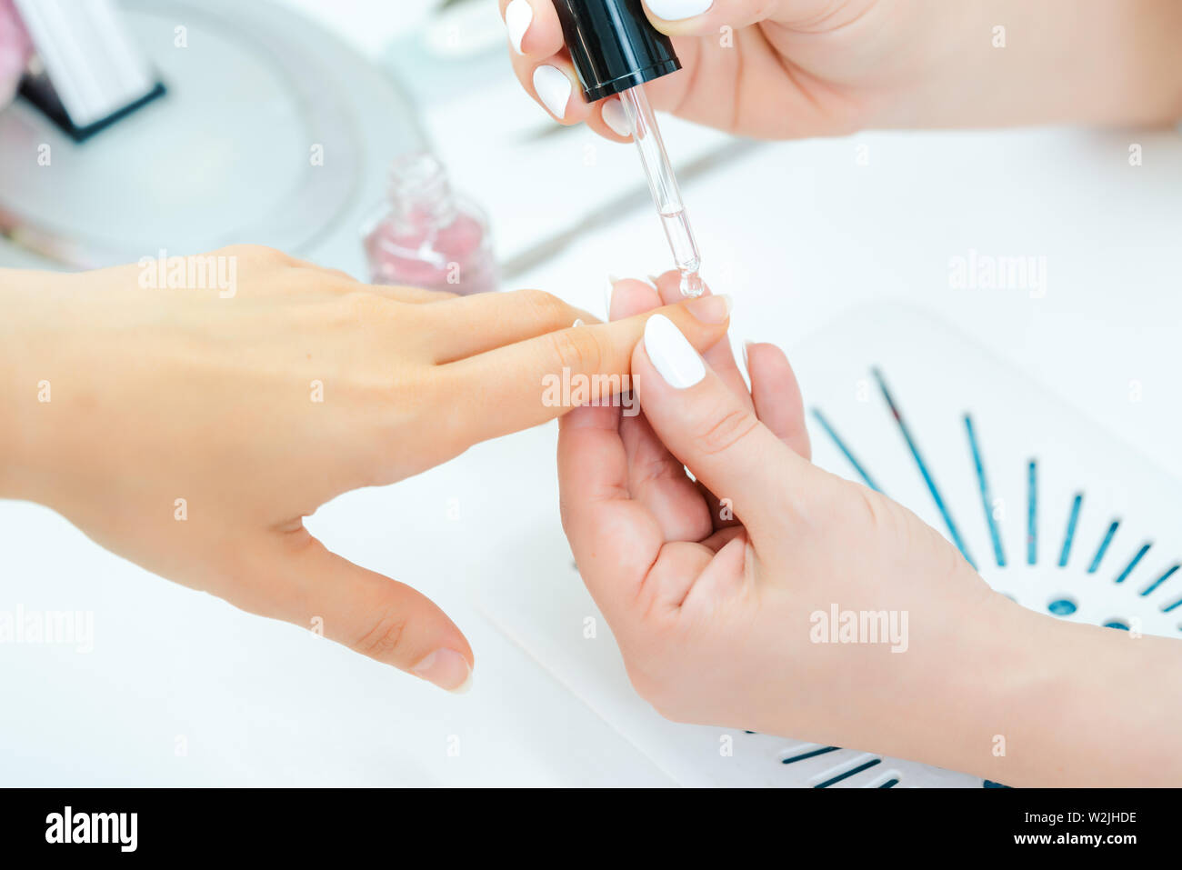 Manicurist versando olio sul dito unghie della donna dopo la pedicure Foto Stock