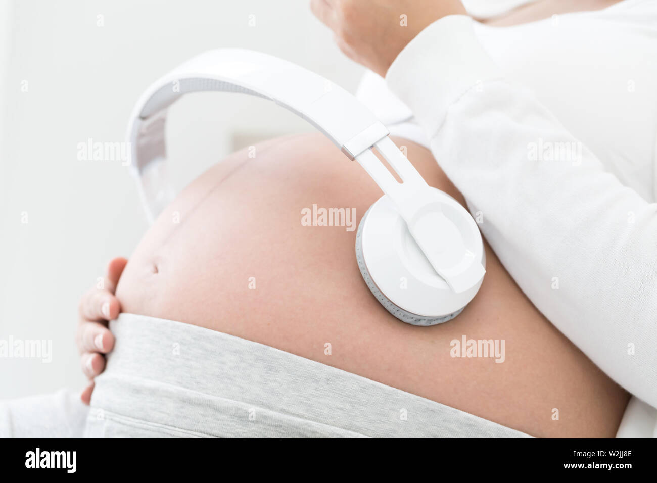 Donne in stato di gravidanza ascoltare musica effetto Mozart buona per il  feto utilizzando gli auricolari attaccati allo stomaco, classica musica di  relax per il bambino durante il Foto stock - Alamy