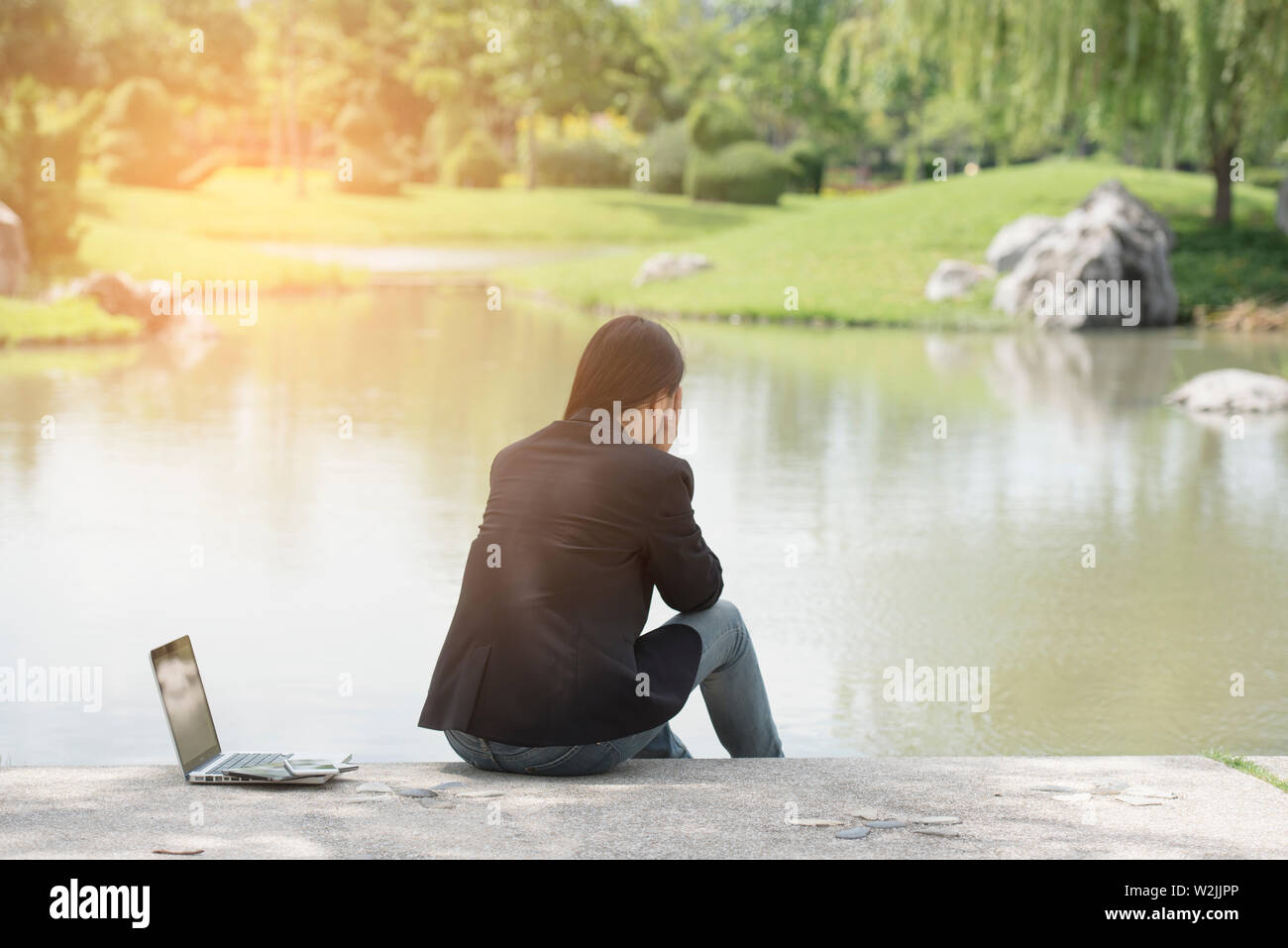 Grave business donna lavorare sodo e con un grave problema in un parco pubblico. Lavorando su laptop all'esterno. Immagine ritagliata femminile di lavorare sul computer portatile mentre si Foto Stock