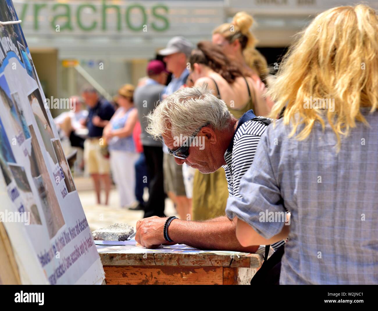 L'uomo delle prenotazioni per tour in barca alle grotte,Agios Spiridon Beach,Agios Spiridon Bay,Paleokastritsa ,Corfù, Grecia, Foto Stock