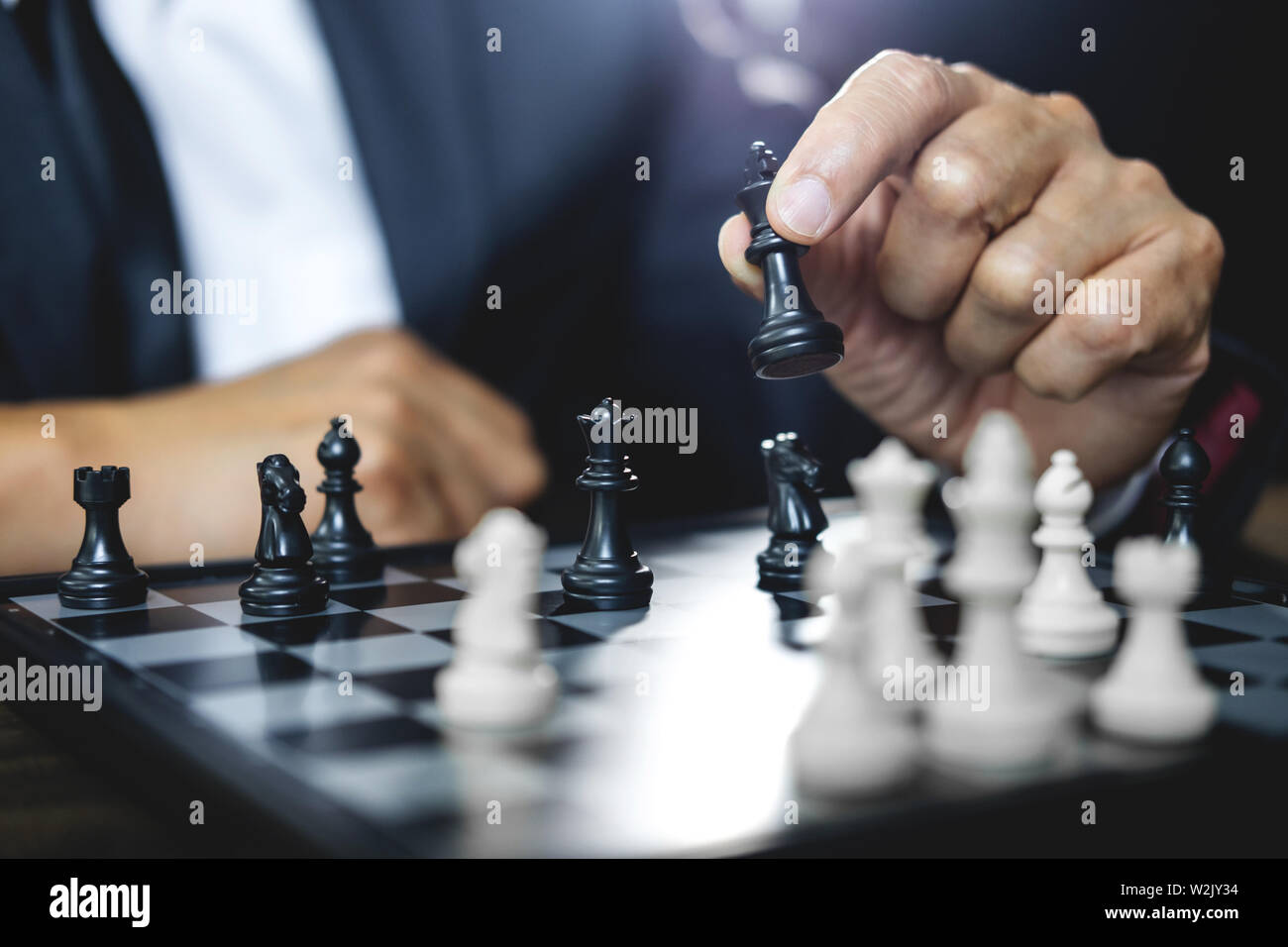 Imprenditore giocando a scacchi e strategia di pensiero circa il crash di rovesciare la squadra opposta e analisi di sviluppo per vincere e di successo. Foto Stock