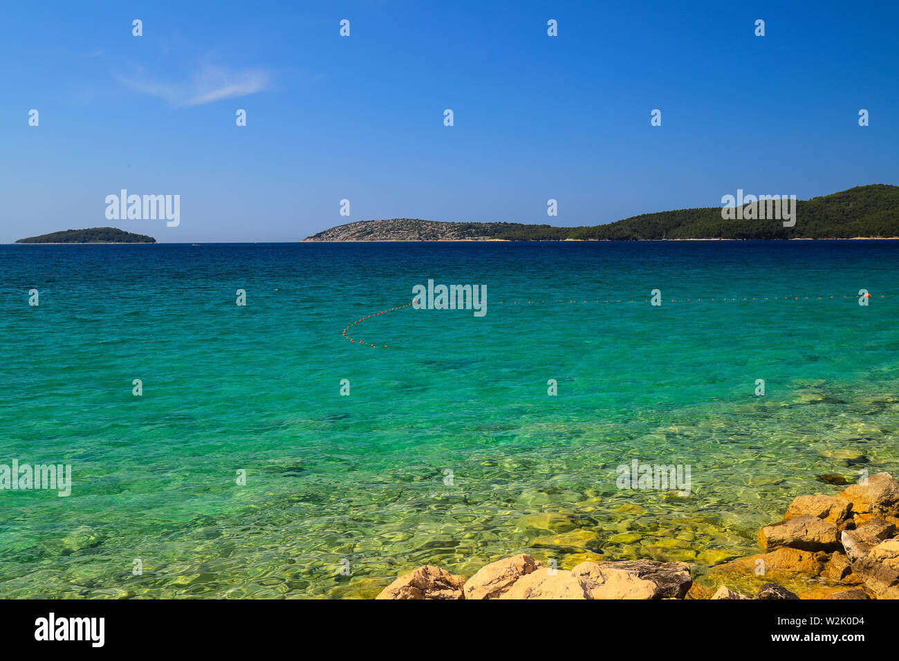 Sullo sfondo del mare di Sibenik, Croazia. Trasparente, acqua chiara su un ambiente ecologicamente pulita e pittoresca spiaggia d'estate. Il croato la vacanza estiva, viaggi e Foto Stock