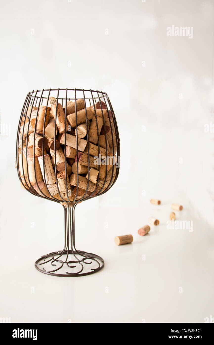 I tappi di sughero da bottiglie all'interno di un vaso che simula un bicchiere  di vino e alcuni tappi di sughero accanto al vaso con uno sfondo bianco  Foto stock - Alamy