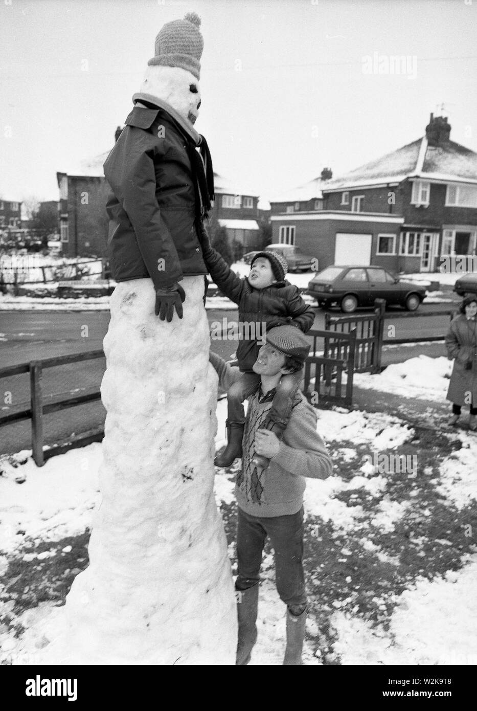 Padre e figlio costruire un pupazzo di neve gigante nel North Yorkshire 1985 Foto Stock