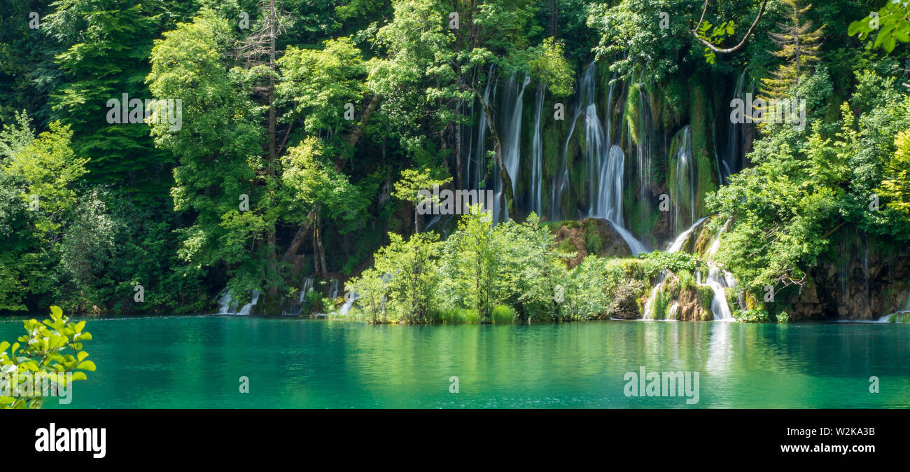 Crystal Clear, acqua pura e correre verso il basso le rocce di muschio in un bellissimo colore azzurro lago presso il Parco Nazionale dei Laghi di Plitvice, Plitvička Jezera, Croazia Foto Stock