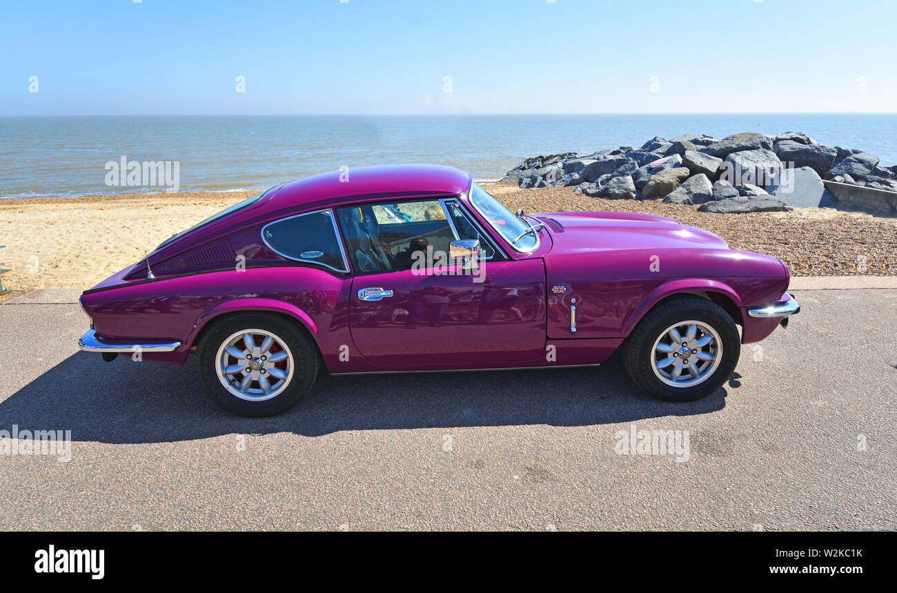 Classic viola Triumph GT6 parcheggiata sul lungomare. Foto Stock