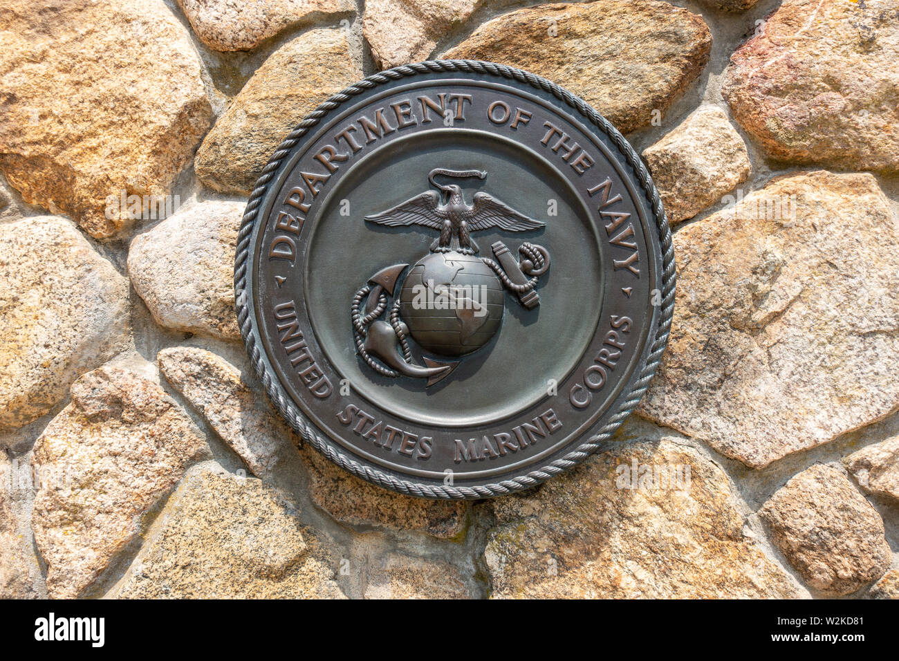 Dipartimento della Marina Militare degli Stati Uniti Marines emblema targa in ottone montato a muro di pietra al Cimitero Nazionale di Bourne, Cape Cod, Massachusetts, STATI UNITI D'AMERICA Foto Stock