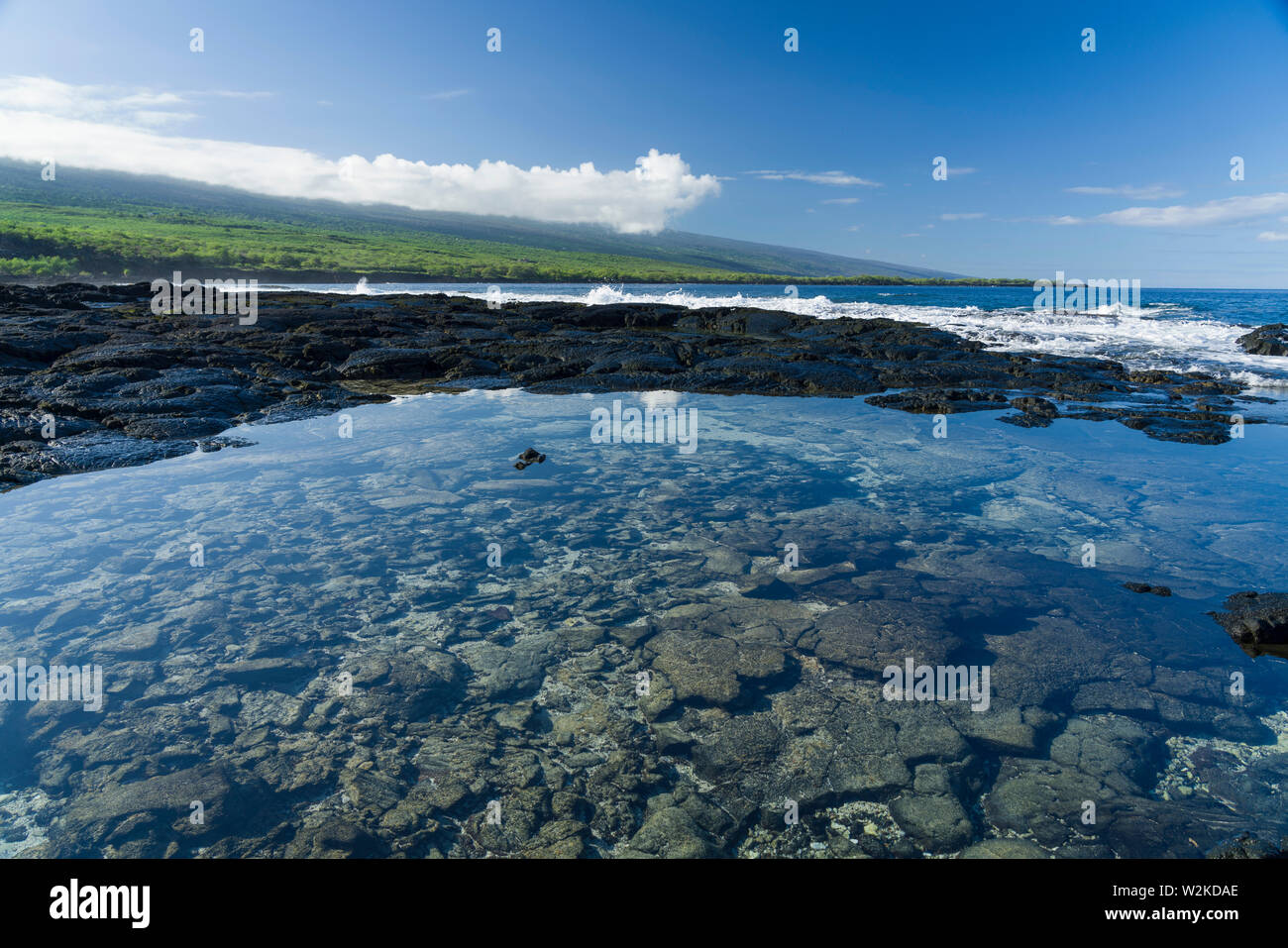 Tranquilla piscina di marea in Pu'uhonua O Honaunau NP in Sud Kona, Hawaii con Mauna Loa distante Foto Stock