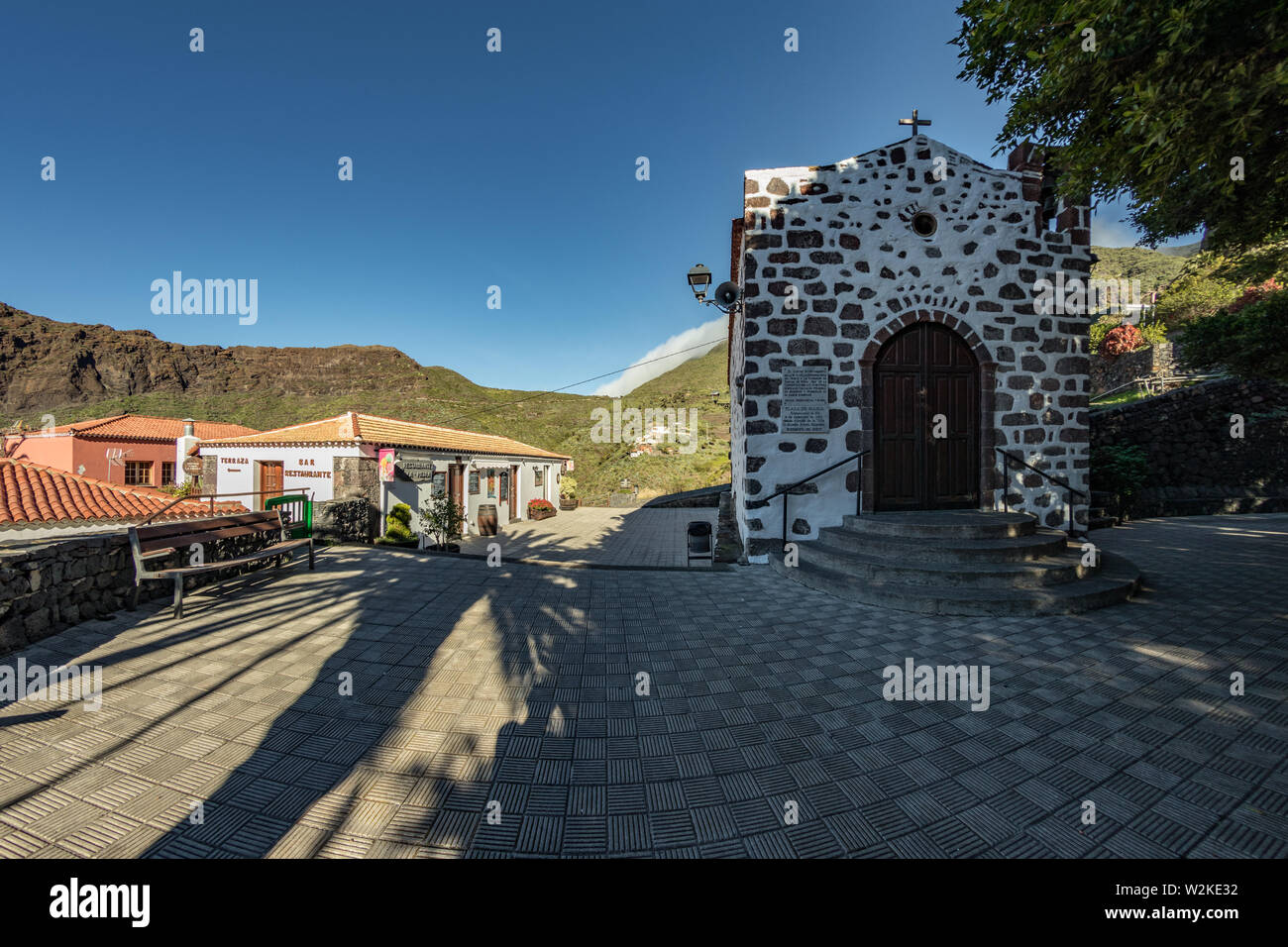 Accogliente villaggio di montagna nascosto in una tranquilla, gola profonda circondata da giardini e foreste subtropicali su Paradise Island. Bella calda giornata di sole. Trav Foto Stock