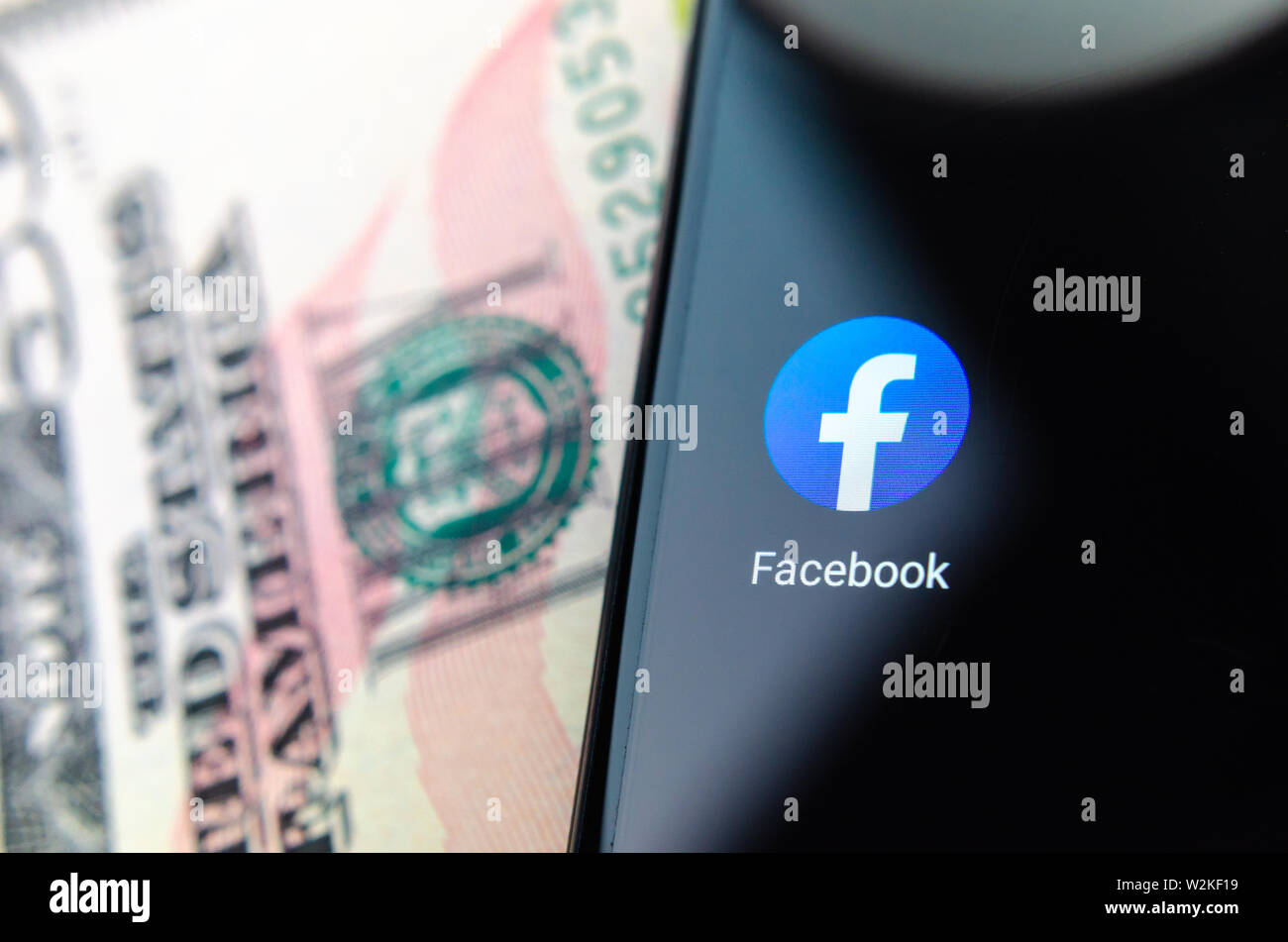 App Facebook icona accanto alla riserva federale simbolo sul 50 dollari in banconote. Illustrare le novità sul lancio di Facebook valuta propria libra. Foto Stock
