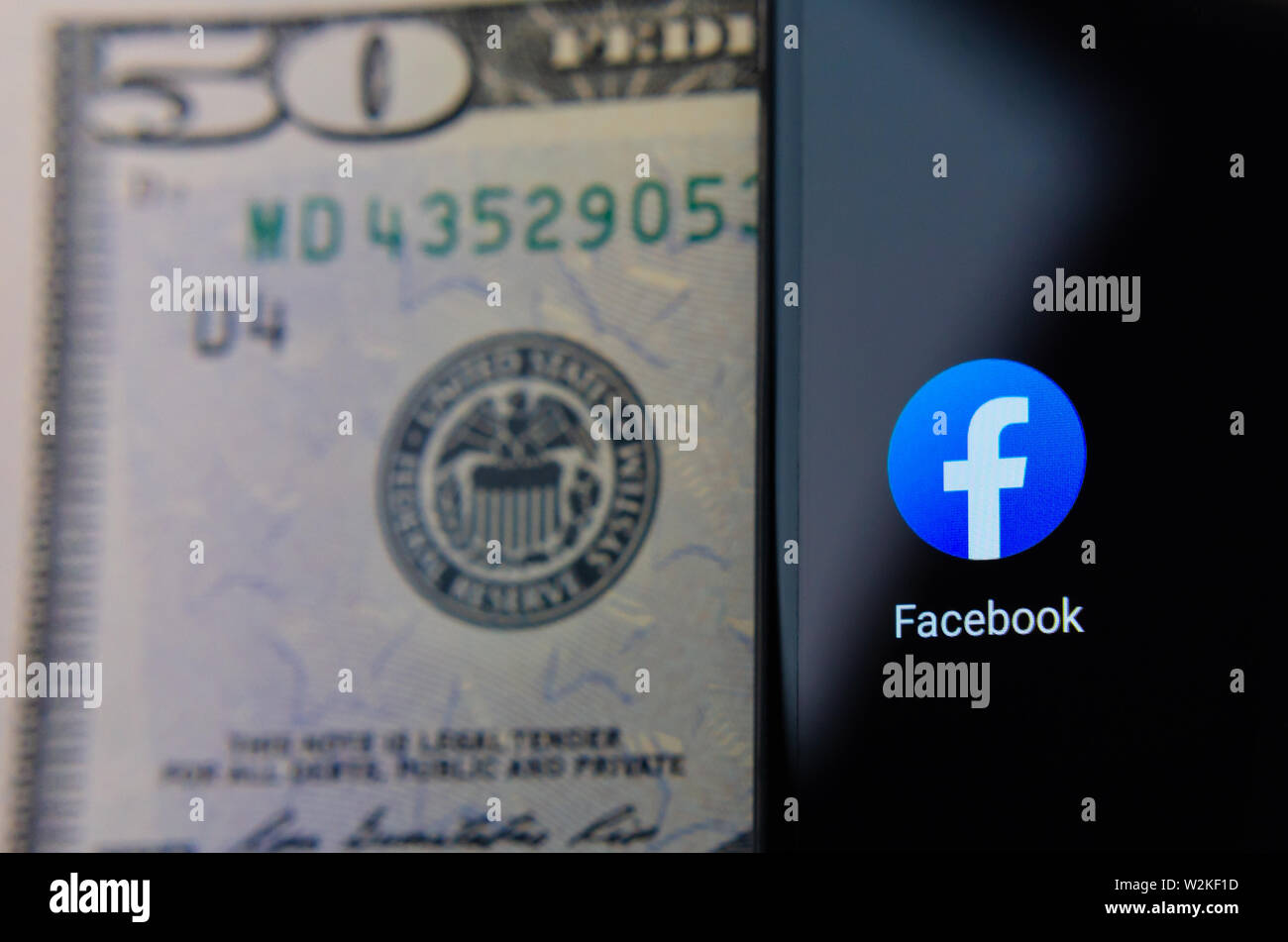 App Facebook icona accanto alla riserva federale simbolo sul 50 dollari in banconote. Illustrare le novità sul lancio di Facebook valuta propria libra. Foto Stock