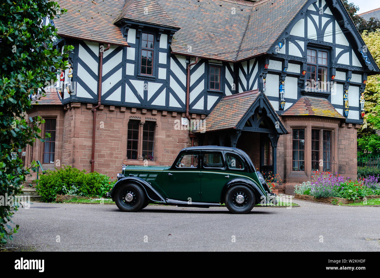 Elegante verde scuro retrò auto nella parte anteriore del vecchio tudor house. Classic Cars festival 'Brums e focacce' a Chester, Regno Unito. Foto Stock