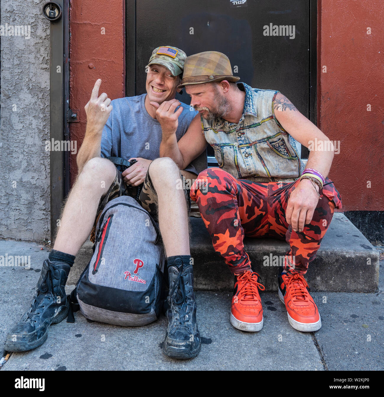 2 uomini adulti di sedersi su un passo sulla strada del sud goofing per un ritratto Foto Stock