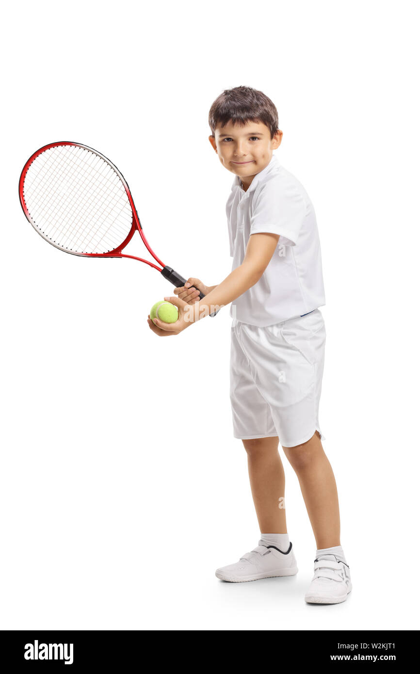 A piena lunghezza Ritratto di un bambino tennista che serve una palla con una racchetta isolati su sfondo bianco Foto Stock