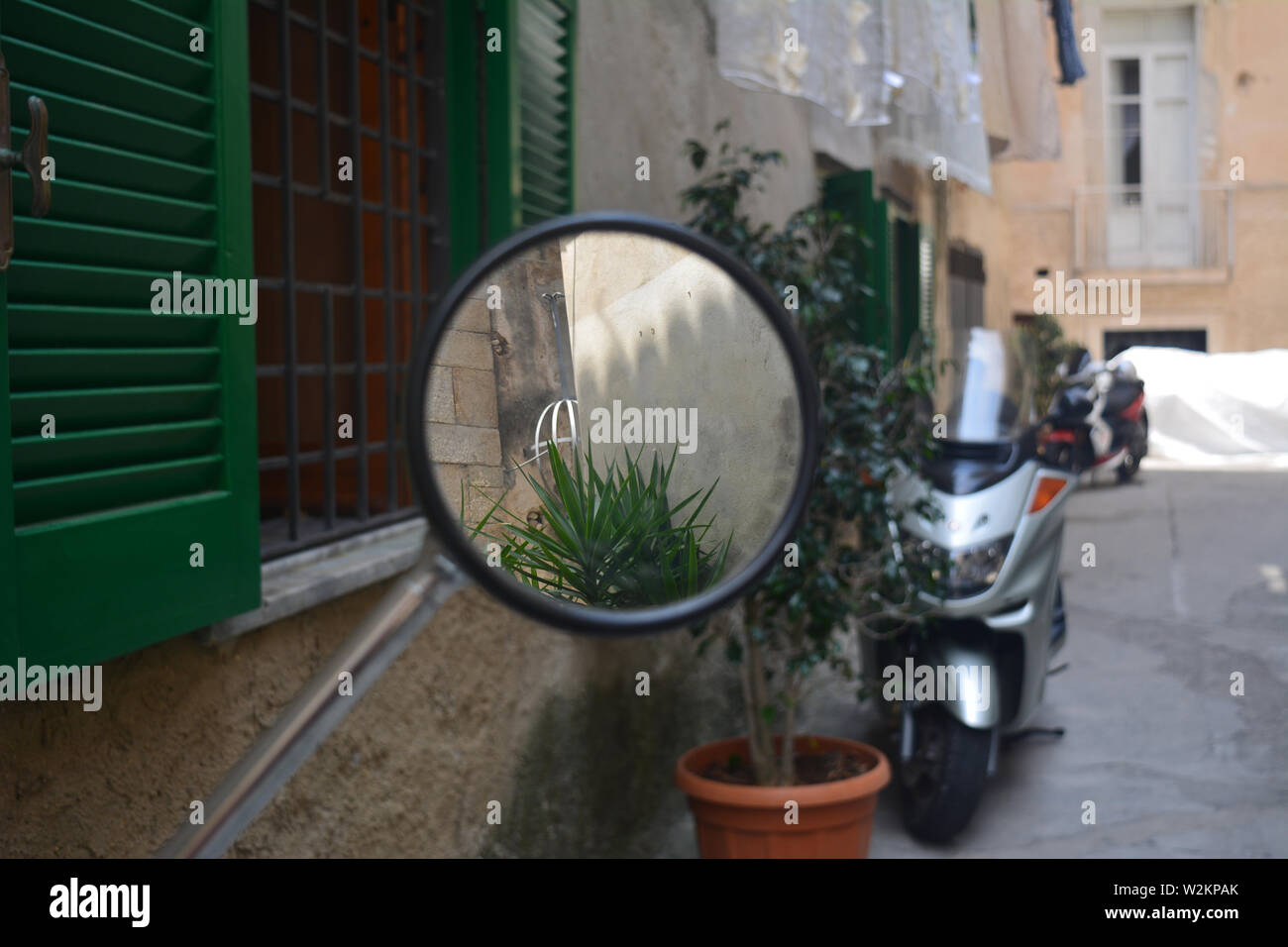Motociclo round dello specchietto retrovisore, su una piccola strada in una città tradizionale in Italia, Calabria. Fotografia perfetta per incorniciare. Foto Stock