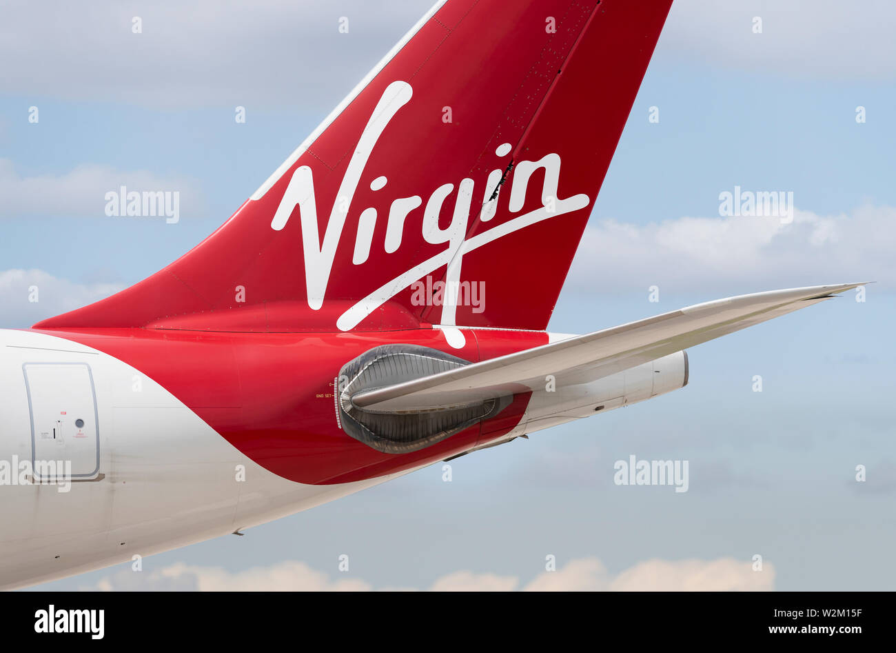 Il tailfin di Virgin Atlantic aereo di linea di rullaggio lungo la pista dell'aeroporto di Manchester. Foto Stock
