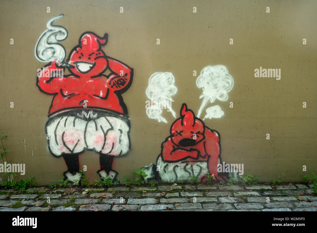 Due strane creature rosse dipinte come graffiti su un muro di cemento. Foto Stock