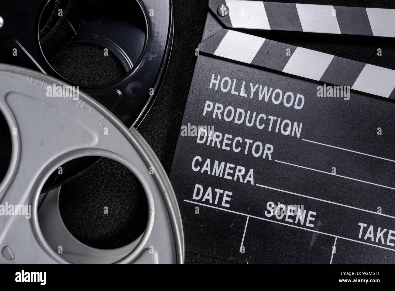Movie clapper e bobina di pellicola su un sfondo di legno Foto Stock