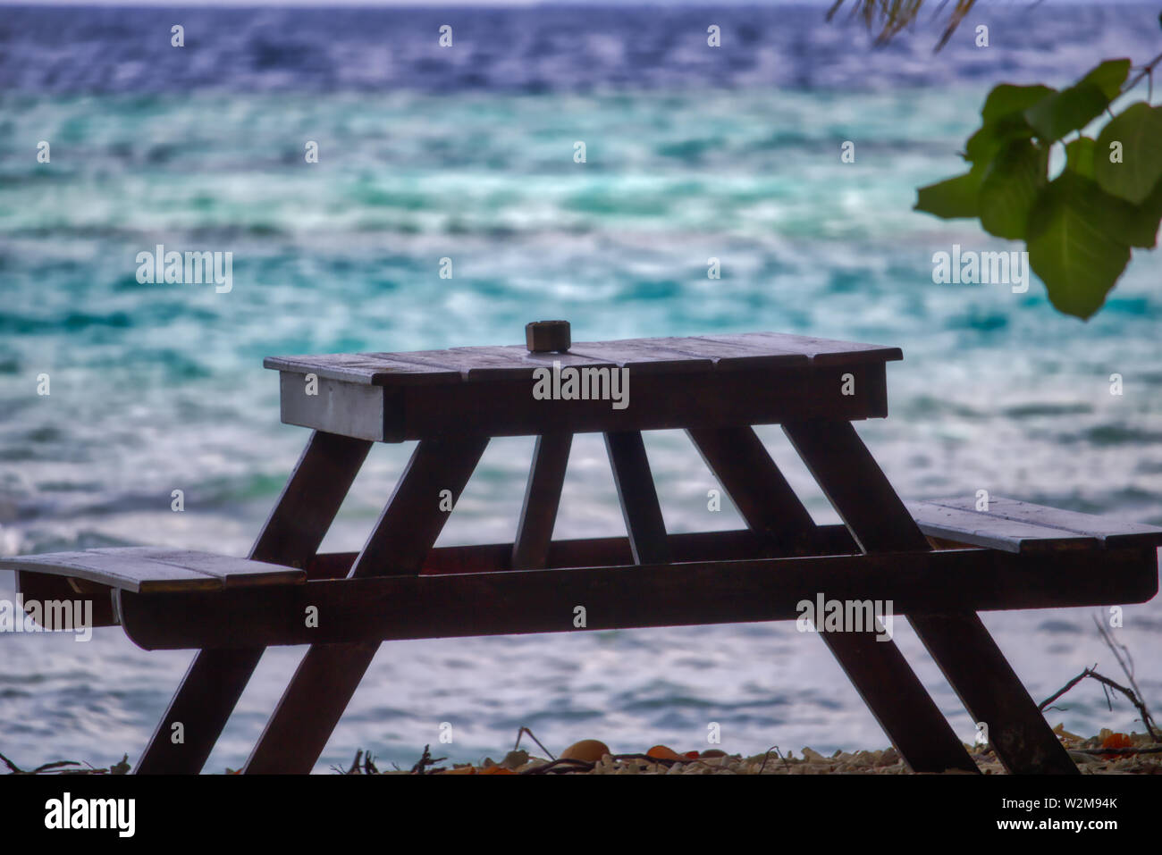 Questa unica foto mostra un tavolo di legno che è un posto romantico sulla spiaggia delle Maldive Foto Stock