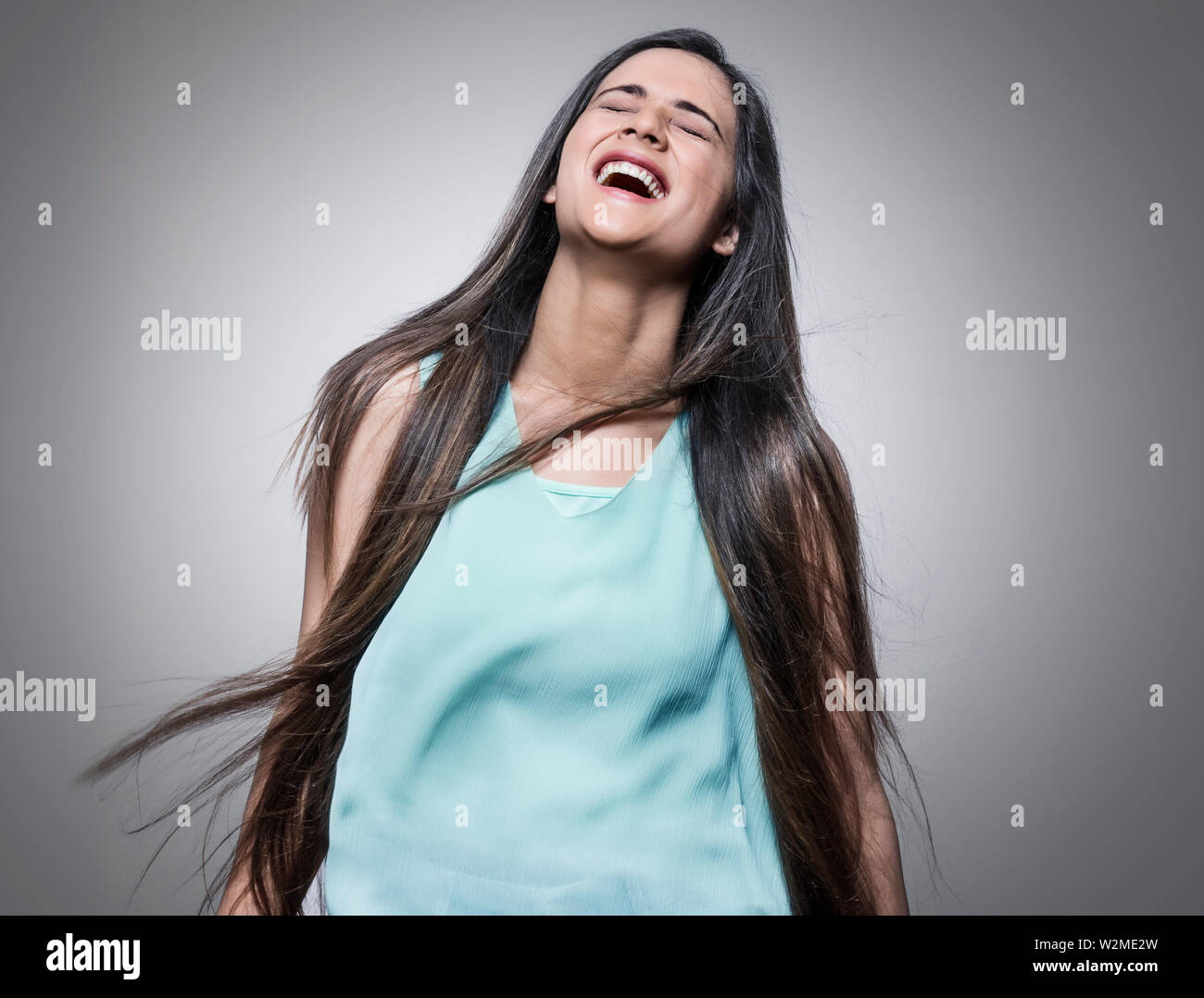 Giovane ragazza ridere con gli occhi chiusi Foto Stock