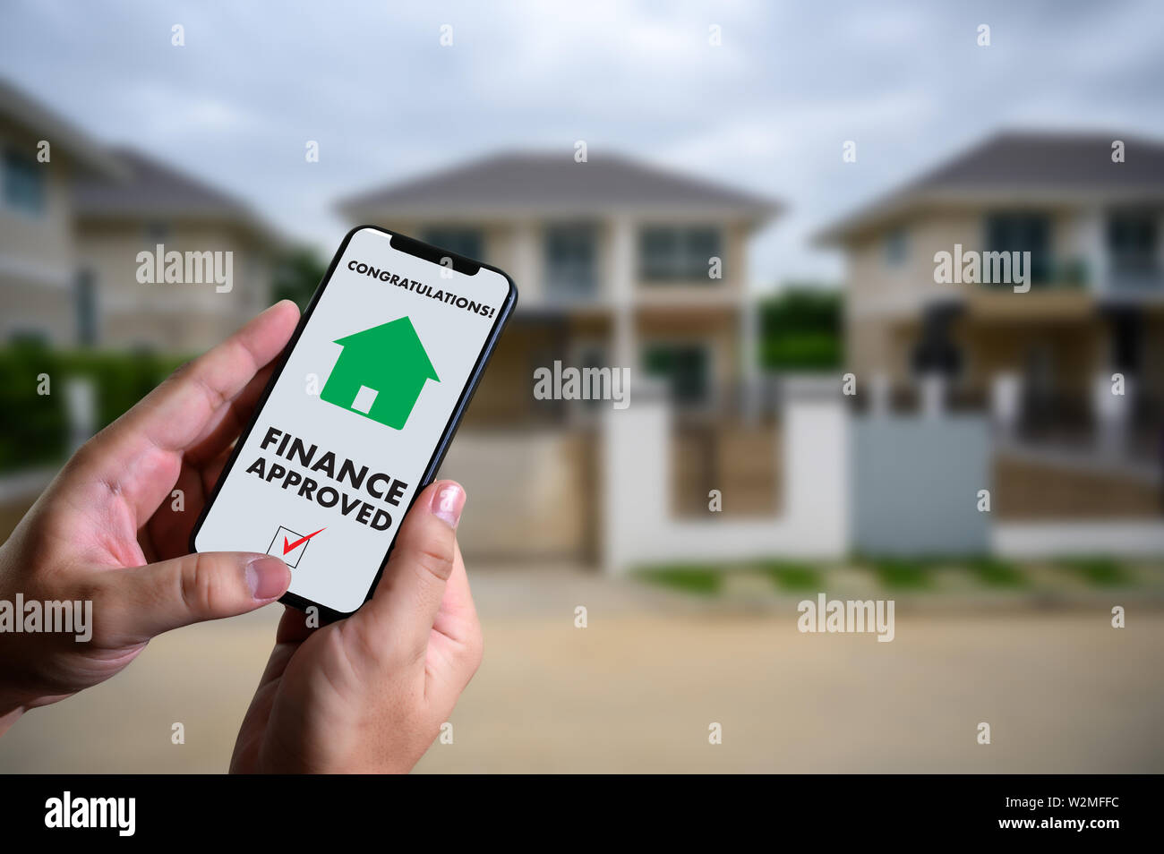 Finanziare l'accordo di prestito e la chiave di casa mutuo ipotecario approvazione sul telefono cellulare in una casa Foto Stock