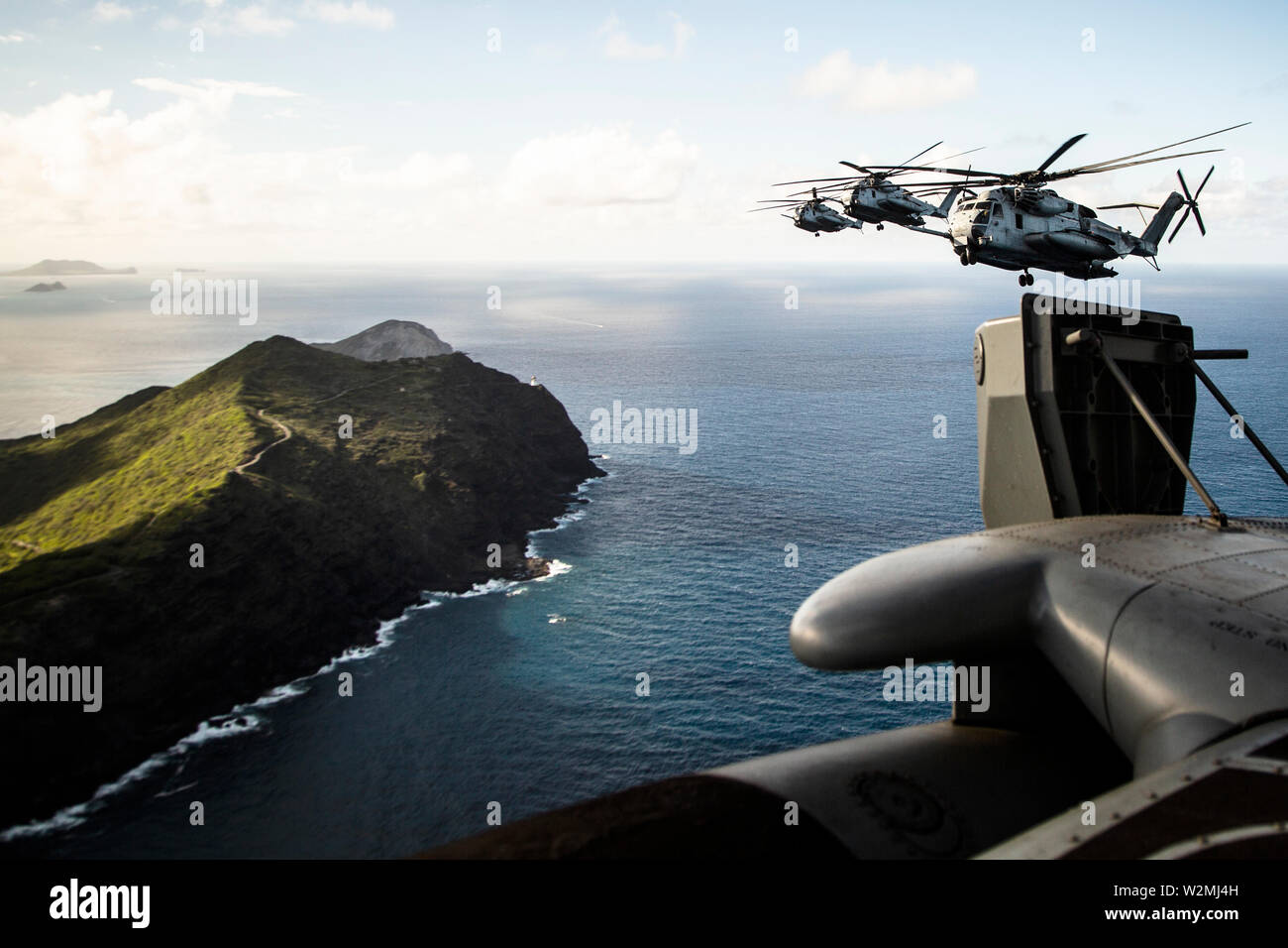 Stati Uniti Marines con Marine elicottero pesante Squadron 463 (HMH-463), Marine Aircraft Group 24, volare vicino alle rive del Kalaeuila in CH-53E Super Stallion elicotteri sull'isola di Oahu, Hawaii il 3 luglio 2019. HMH-463 ha condotto un "Moto volo" che ha dato la manutenzione aeromobili Marines che ha lavorato sul CH-53E Super stalloni un tour intorno all'isola per commemorare il loro adempimento della missione e del duro lavoro. (U.S. Marine Corps foto di Cpl. Eric Tso) Foto Stock