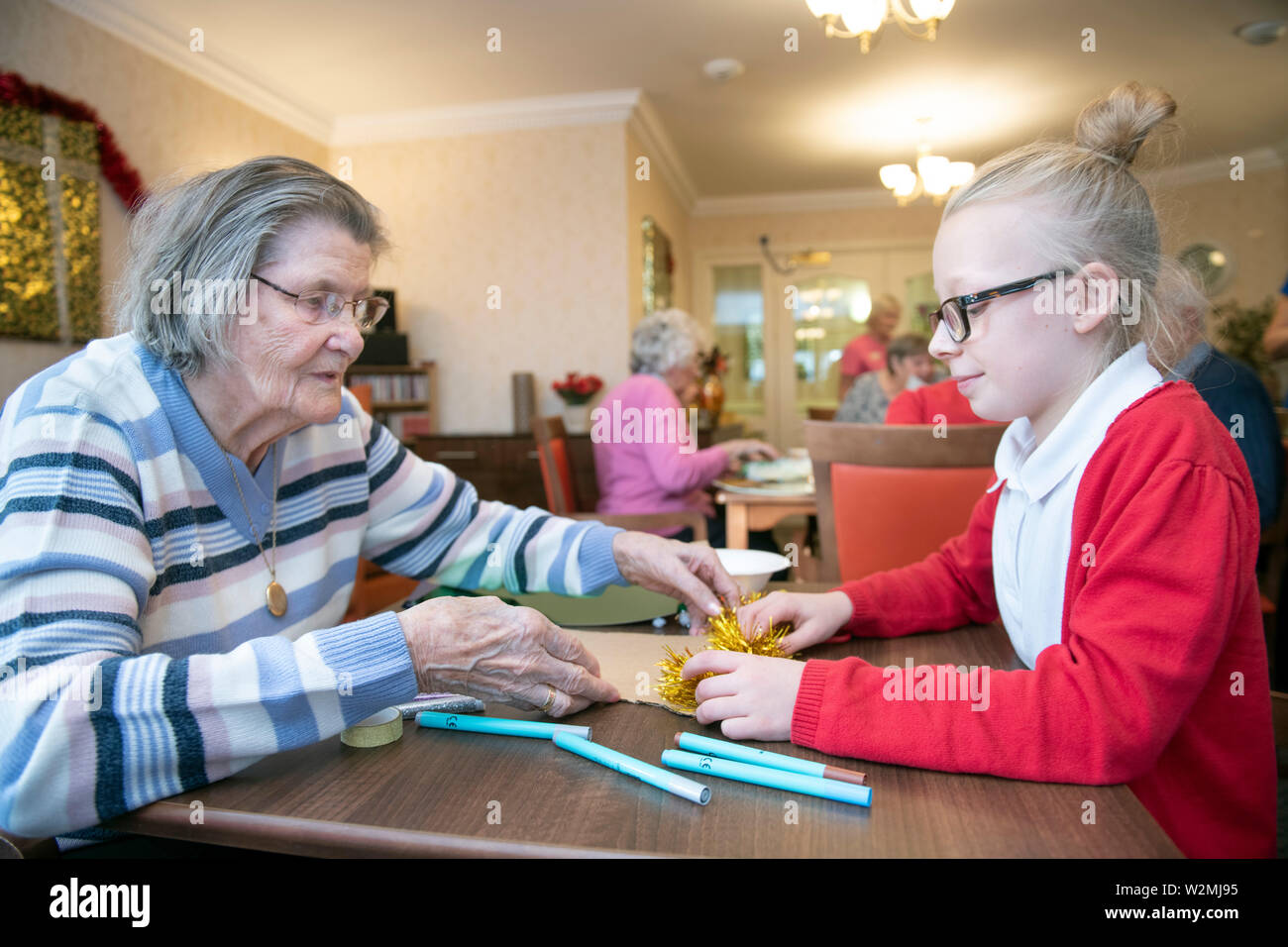 Allievi per l area di Bristol visitare case di cura per rendere il Natale decorazioni con i residenti in un programma organizzato dalla carità viva attività Foto Stock