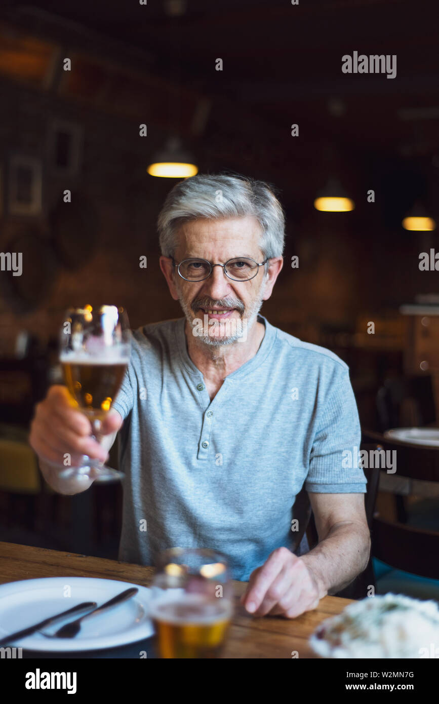 Senior uomo bevendo una birra al bar Foto Stock