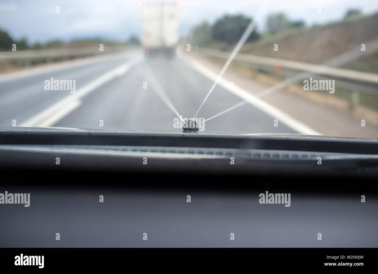 Rondella di vetro in azione mentre sta guidando dietro lento carrello. Vista dall'interno della vettura. Foto Stock