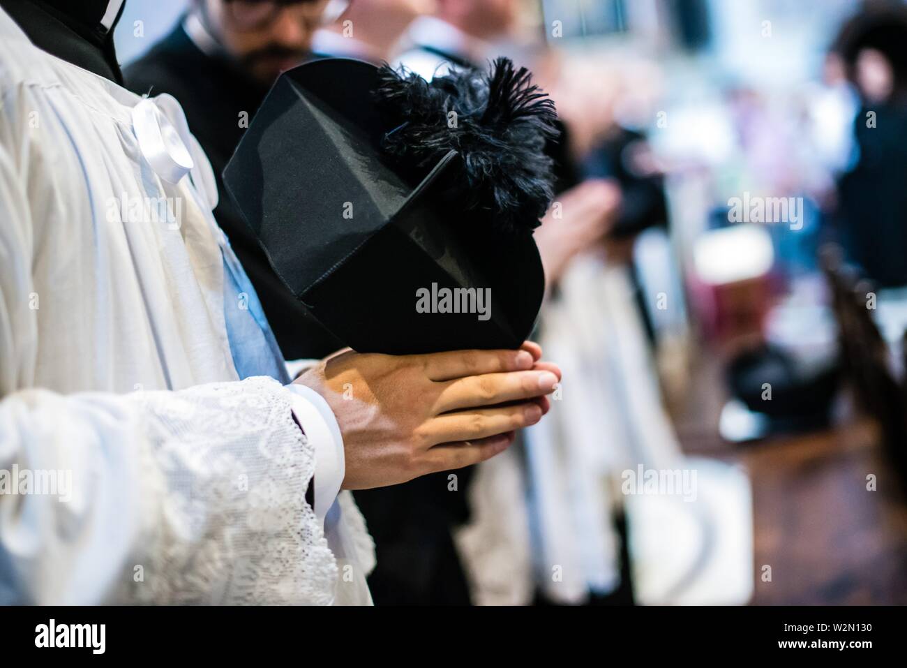 Mani unite in preghiera del sacerdote con il cappello in mano Foto stock -  Alamy