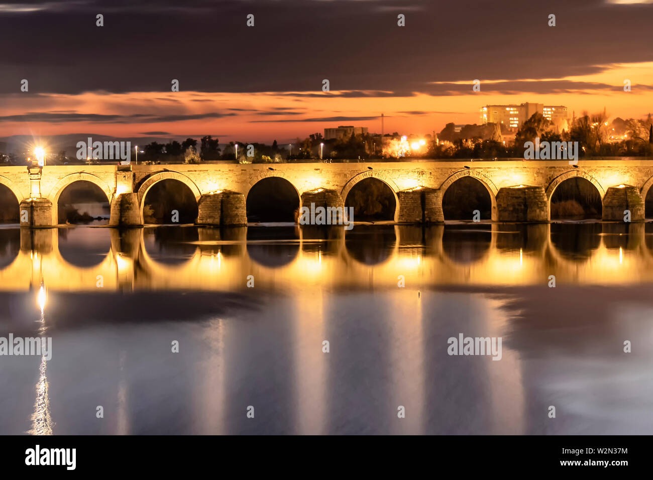 Illuminata ponte romano sul fiume Guadalquivir in serata a Cordoba, Andalusia, Spagna Foto Stock