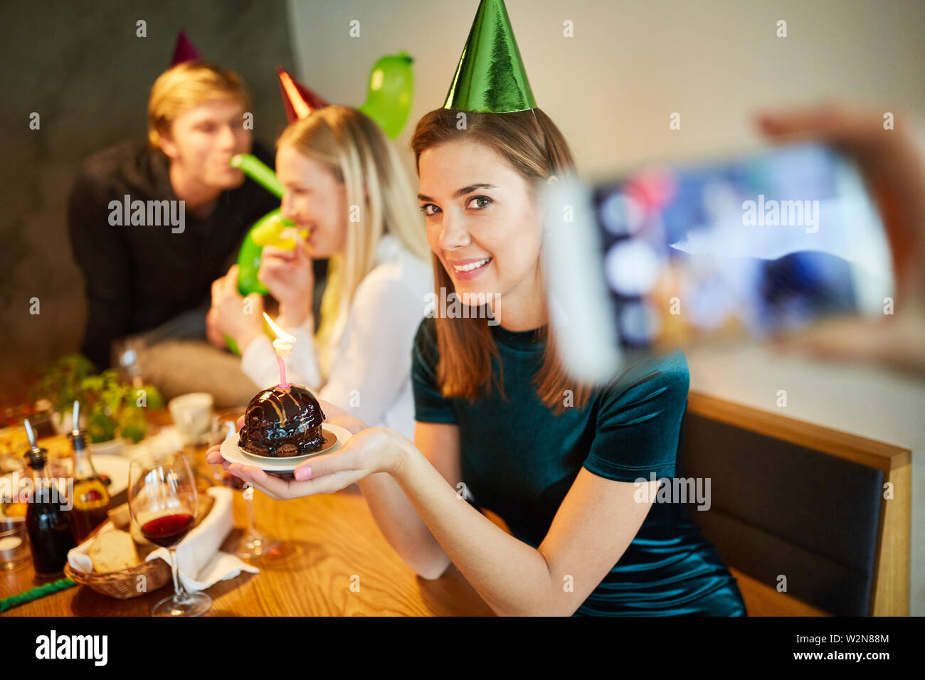 Foodblogger prende le immagini di un pezzo di torta ad una festa di compleanno Foto Stock