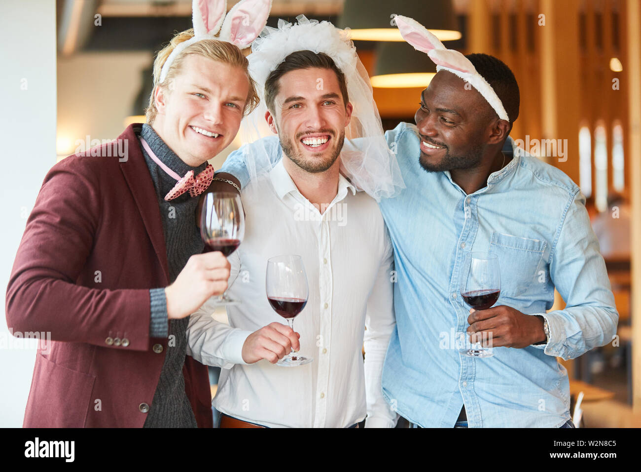 Amici festeggiare felice festa di laurea e bere il vino rosso insieme Foto Stock