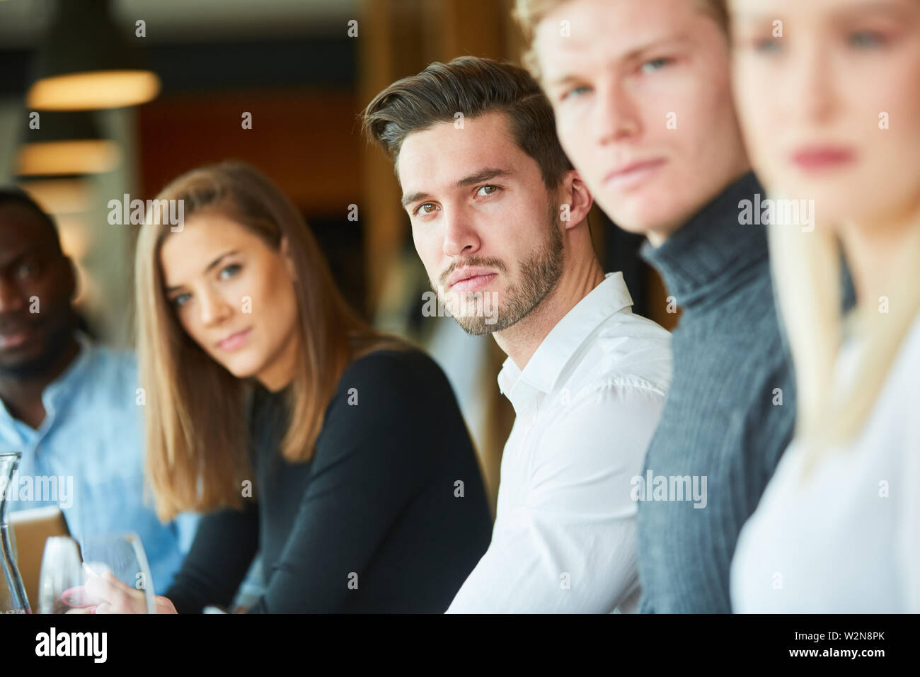 I giovani nel ristorante sono silenziosi e ad esaminare seriamente la fotocamera Foto Stock