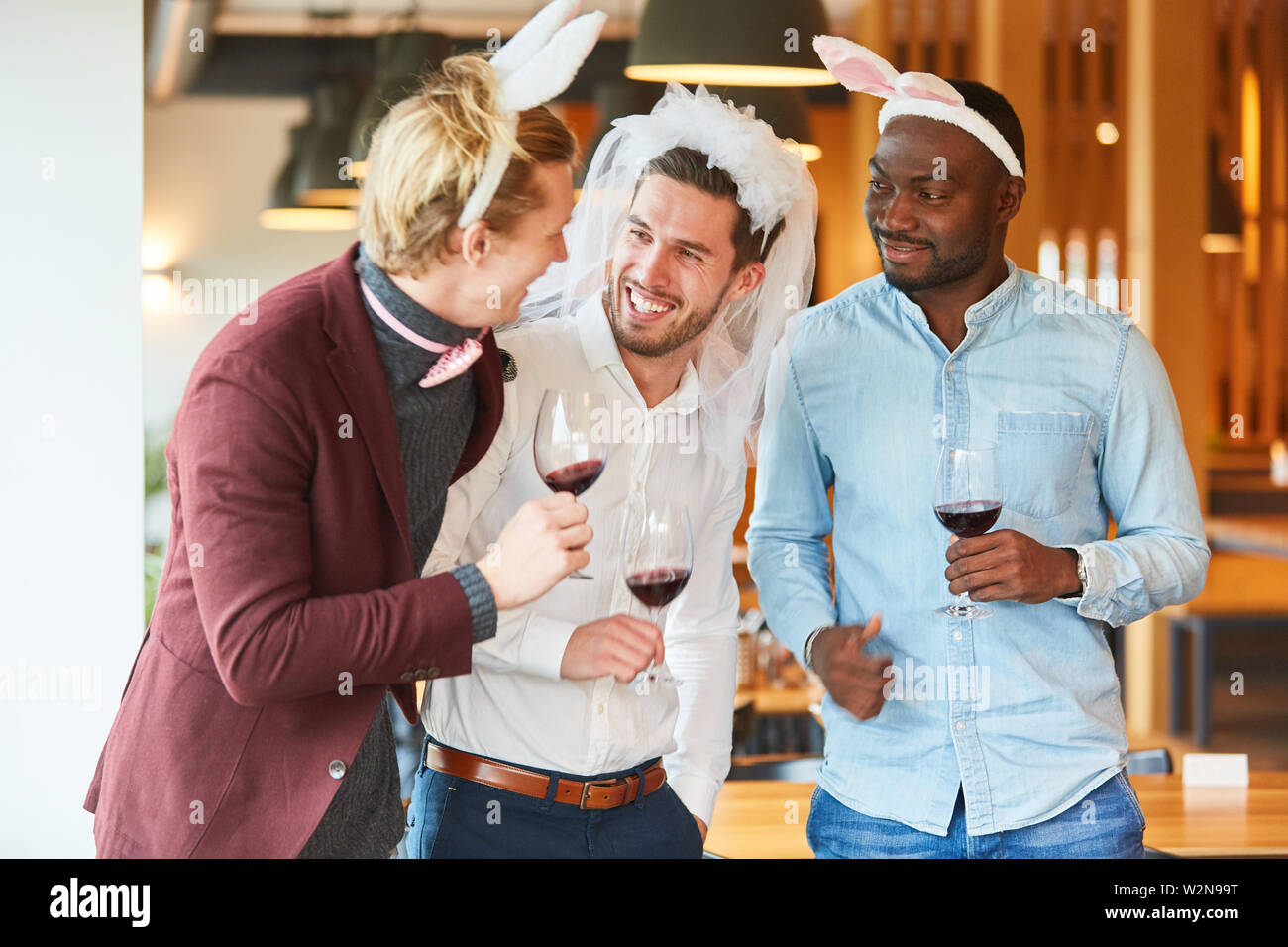 Gli amici di travestimento divertente festeggiare un addio al celibato in un bar Foto Stock