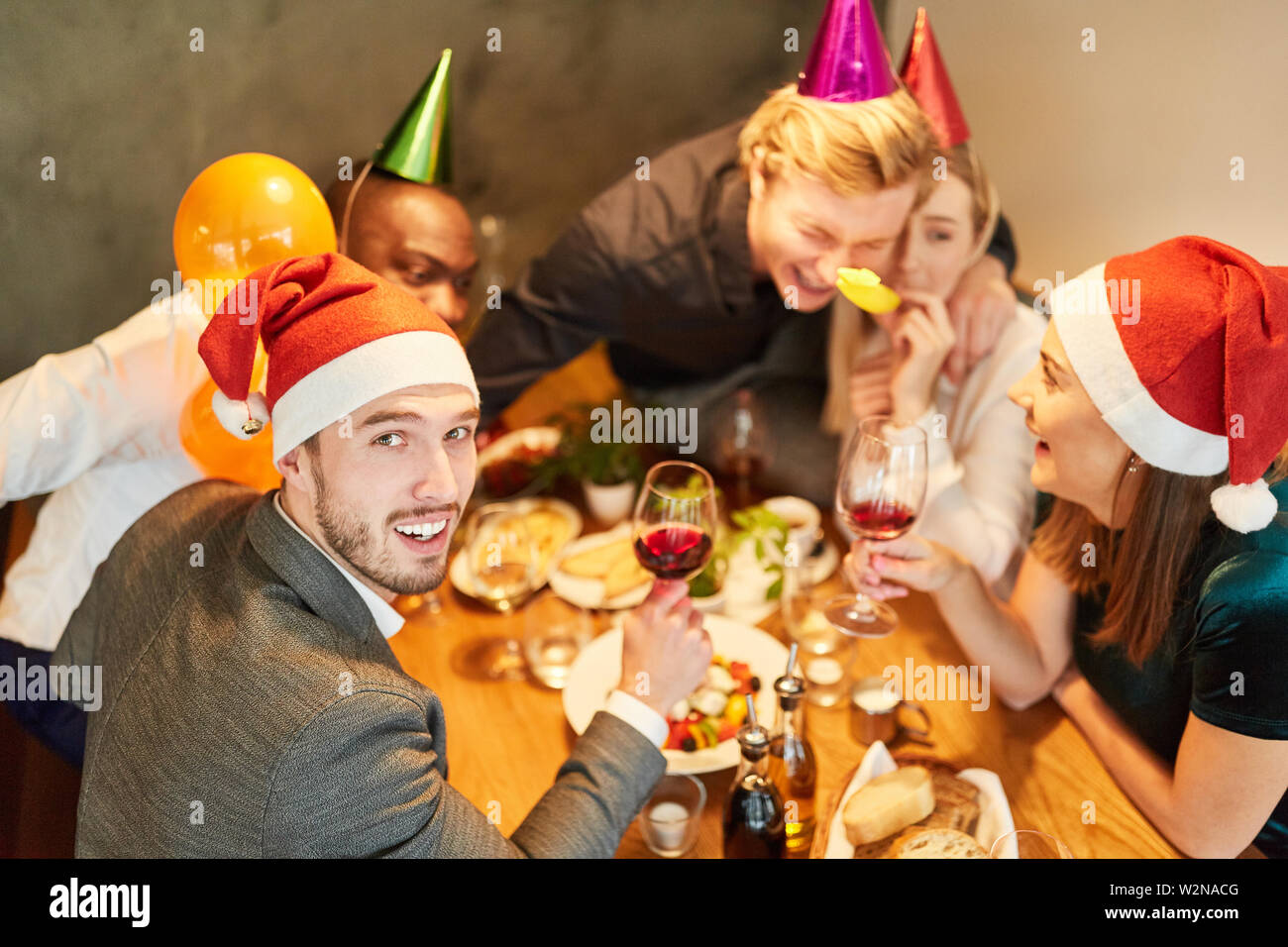 Amici divertiti alla festa di Natale nel divertente travestimento nel ristorante Foto Stock