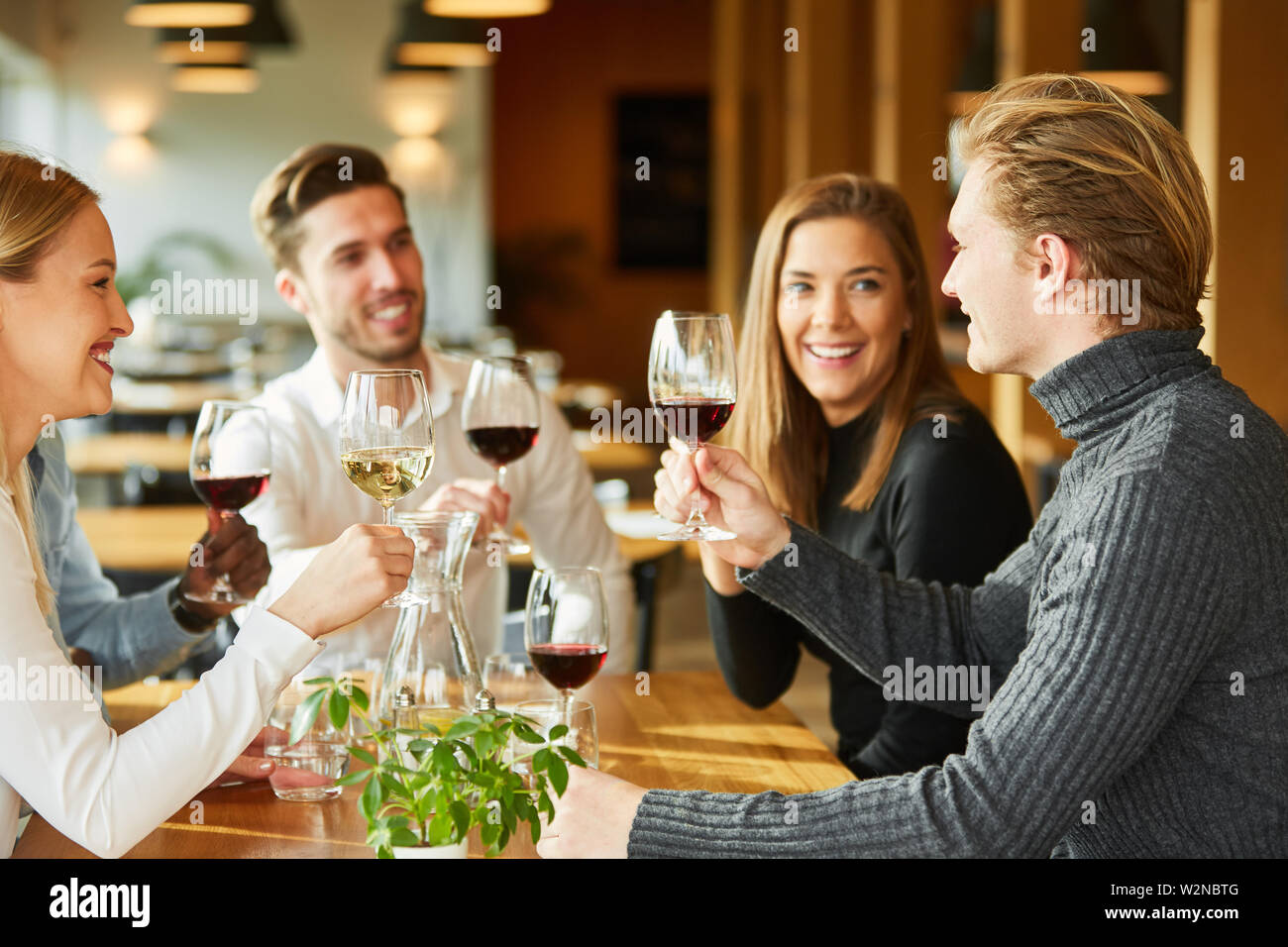 Amici festeggiare insieme e bere un bicchiere di vino presso il ristorante o il bar Foto Stock