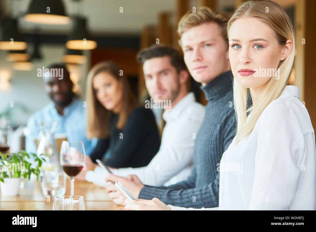 I giovani nel ristorante con mobile tossicodipendenze silenziosamente in silenzio Foto Stock
