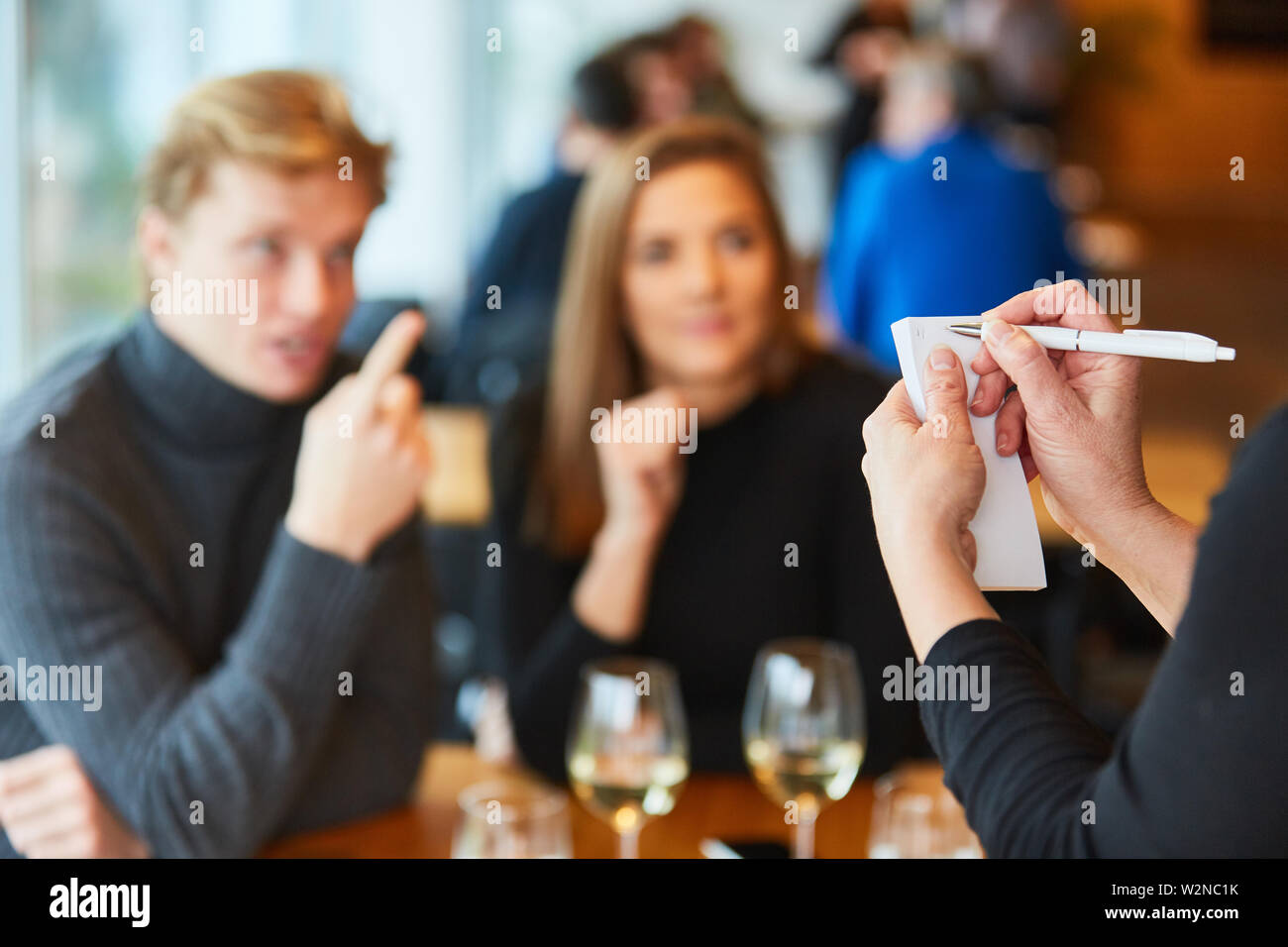 Il personale di servizio o il cameriere note ordine da gli ospiti nel bistrò o ristorante Foto Stock